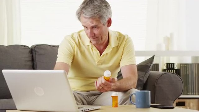 Senior man checking laptop for digital prescription