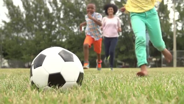 Slow Motion Sequence Of Family Playing Soccer In Park 