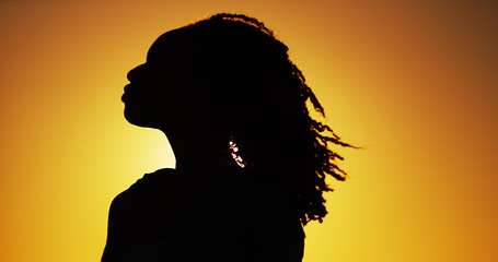 Silhouette of African woman standing at sunset