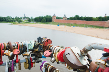 NOVGOROD, RUSSIA - JULY 8: Locks attached on railing of a pedestrian bridge over the river Volkhov. Russian city wedding tradition.