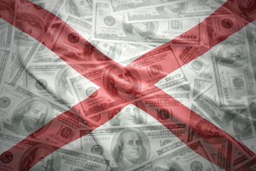 colorful waving alabama state flag on a american dollar money background