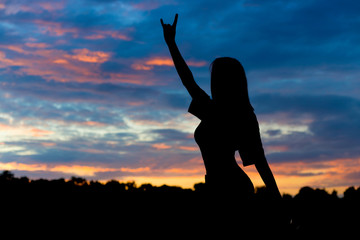 silhouette of beautiful sexy woman on the background of sunset