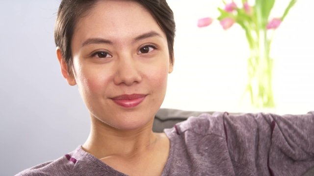 Attractive Chinese woman smiling on couch