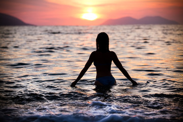 Gorgeous sexy fit woman silhouette swimming in sunset.Free happy woman enjoying sunset. Beautiful...