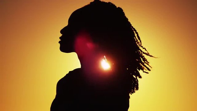 Beautiful Silhouette of African woman standing at sunset