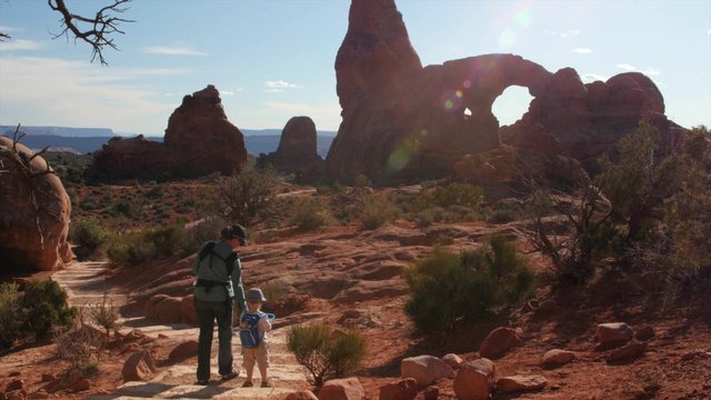 A mother and kids hiking at turret arch in arches national park