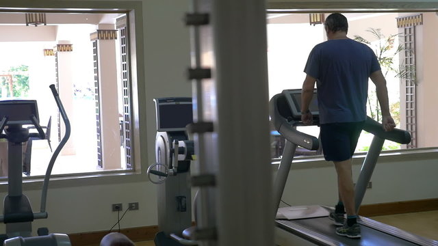 Working out on treadmill in modern gym