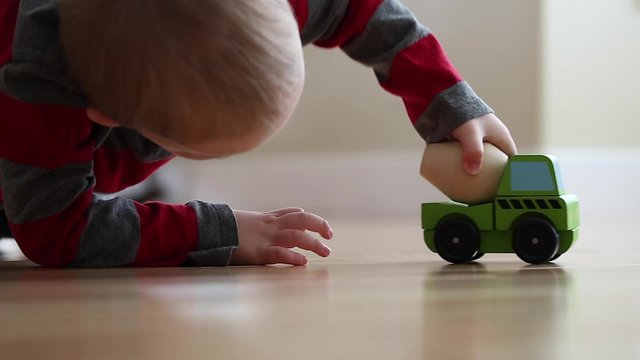 little boy plays with his toy cement truck