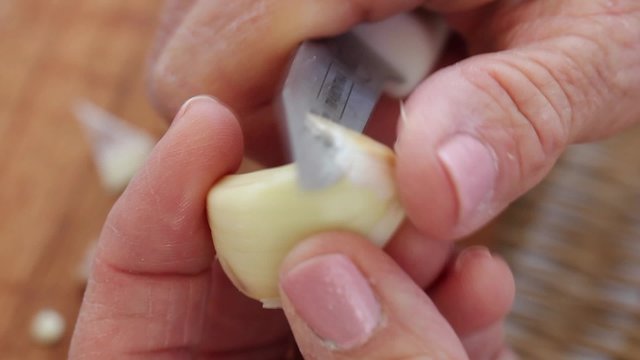 a woman peeling fresh garlic