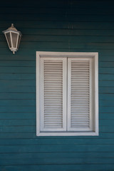 Colonial style. White window on woody wall.