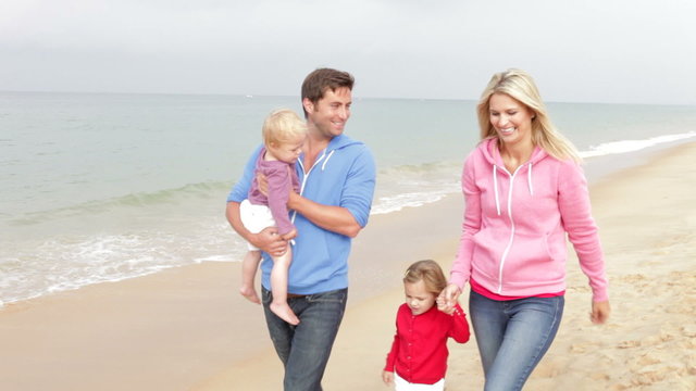 Family Walking Along Beach Together