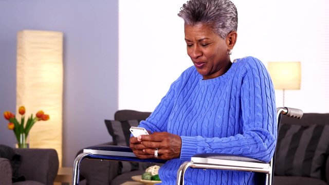 Mature black woman laughing and texting