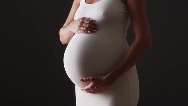 Beautiful pregnant woman rubbing her belly