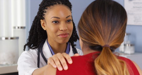 Close up of African American physician with hand on shoulder of patient