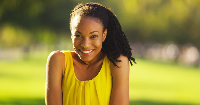 Happy black woman smiling in a park