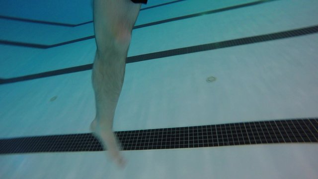 Underwater shot of man treading water at pool with legs
