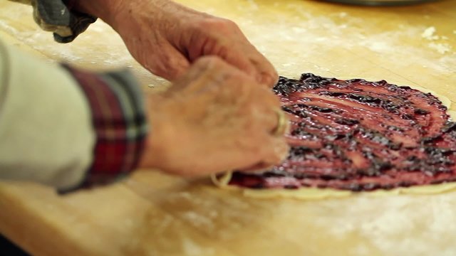 a woman making a berry pie pastry