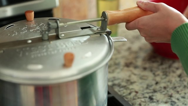 A Woman Cooking Popcorn On The Gas Stove