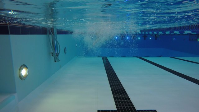 An underwater shot man swimming backstroke in a pool