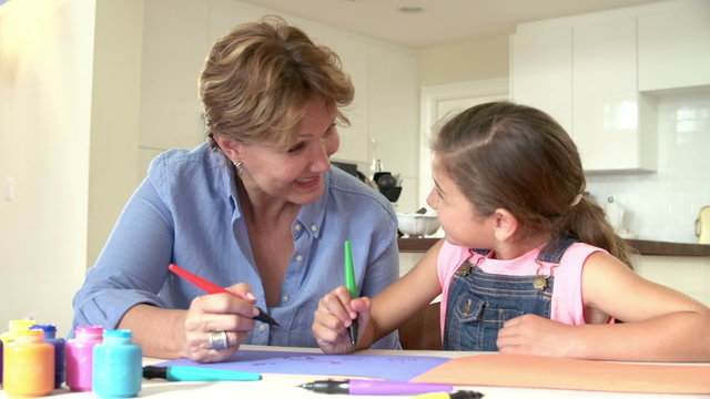 Grandmother Drawing Picture With Granddaughter At Home