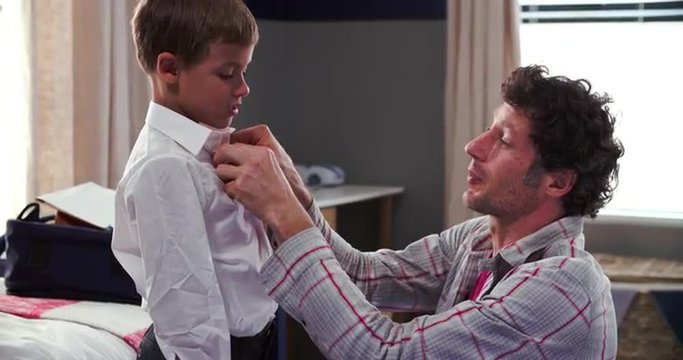 Father Getting Son Dressed Ready For School
