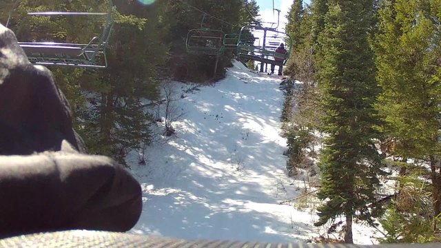 skiers on chairlift in spring