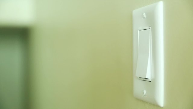 hand turning on and off a light switch