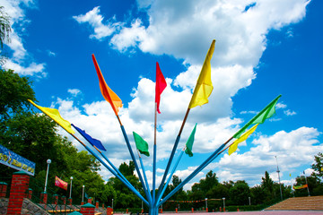 flags of different colors against the sky