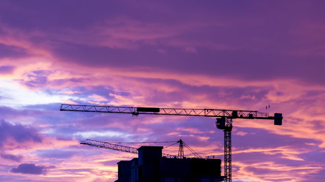 Silhouette Crane Working In Construction Site And Twilight Sky (zoom out)