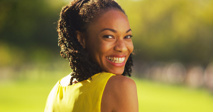 Cute black woman smiling in a park