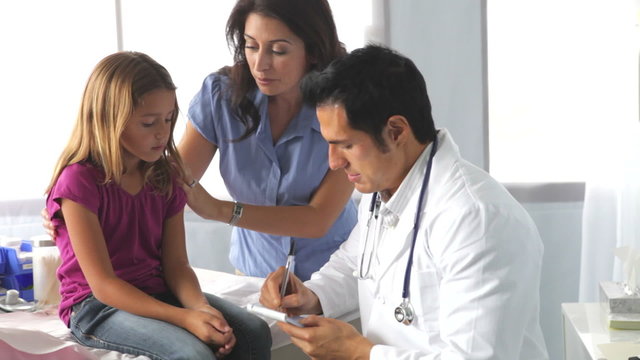 Mother And Child Visiting Doctor's Office