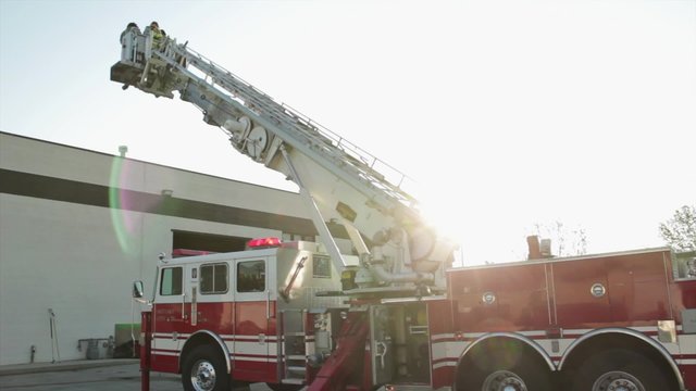 firefighters on fire truck latter