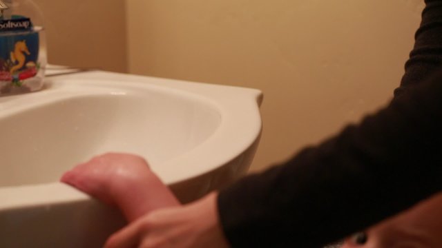 a mother helping her toddler wash hands