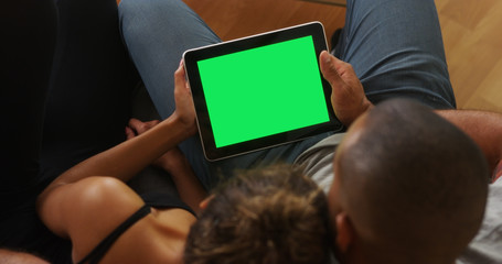 African couple holding tablet with greenscreen