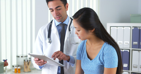 Asian patient talking with her doctor about her test results