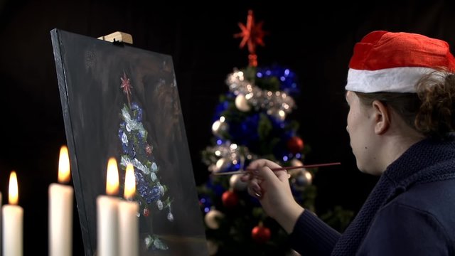 Side shot of a lady drawing Christmas tree