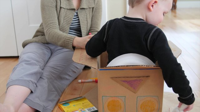 Stay at home mother makes a spaceship with her toddler