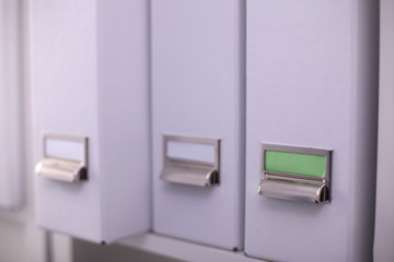 File folders, standing on  shelves in the background