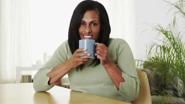 Senior black woman drinking hot coffee