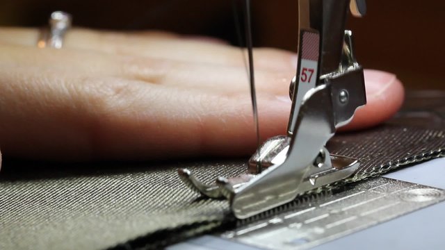 A woman uses a sewing machine on a craft project in her home