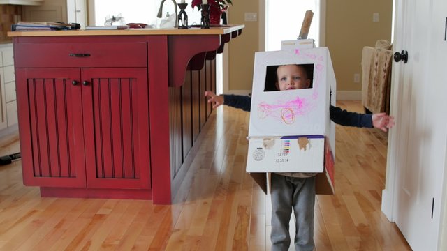 A boy playing in a homemade robot costume