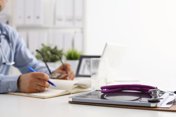 Male doctor using a laptop, sitting at his desk
