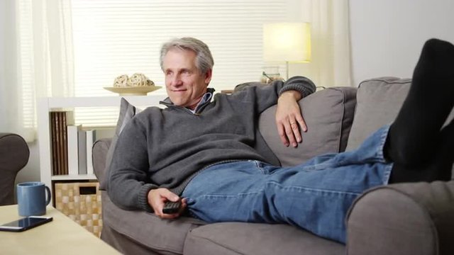 Elderly man watching tv on couch