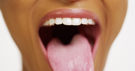 Close up of African woman with white teeth smiling and sticking tongue out © Mark Adams