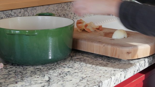 Mother dices an onion on a cutting board