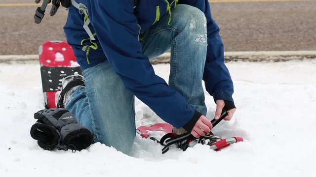 man putting on his snowshoes