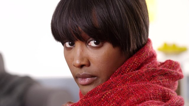 Sultry black woman wearing red blanket