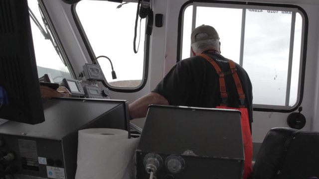 captain steering his fishing boat