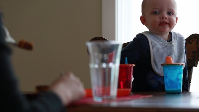 a toddler eating breakfast at the table