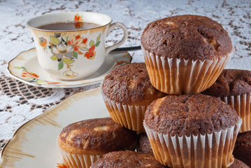 Classical tea time with tasty muffins over retro ambient with porcelain dishes.